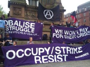 purple banners reading "occupy/strike/resist", "globalise the struggle", "we won't pay for their crisis", and a circle-A flag