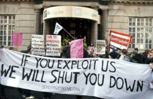 Mass picket holding banner "if you exploit us we will shut you down"