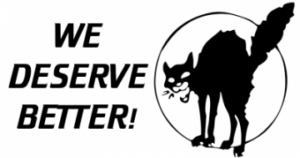 Black cat with its back arched, tail raised, and mouth open in a hiss. With text "we deserve better!"